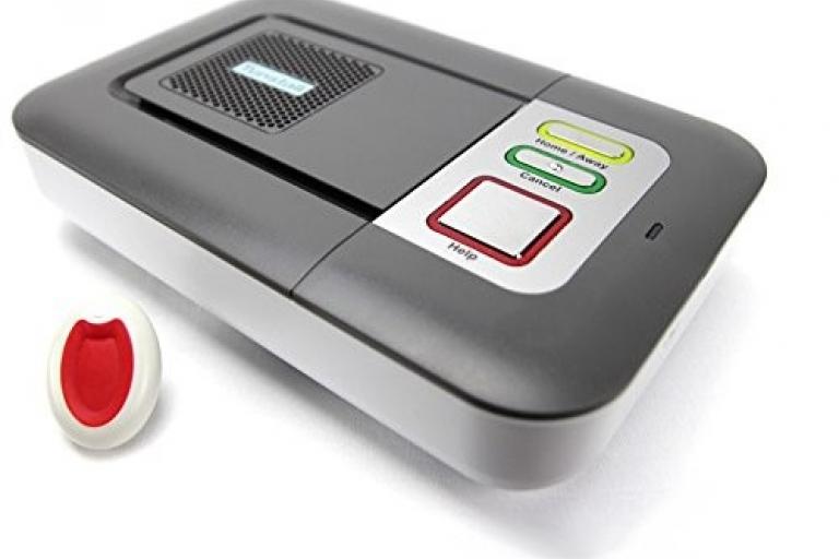 A Community Alarm is a small grey and white plastic box with a speaker and three buttons. A red button, a yellow button and a green button.