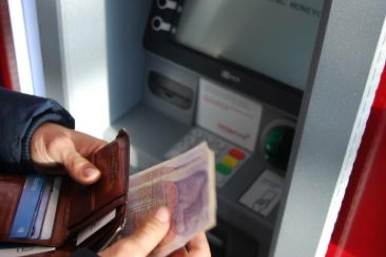 Person taking money out of cash machine.