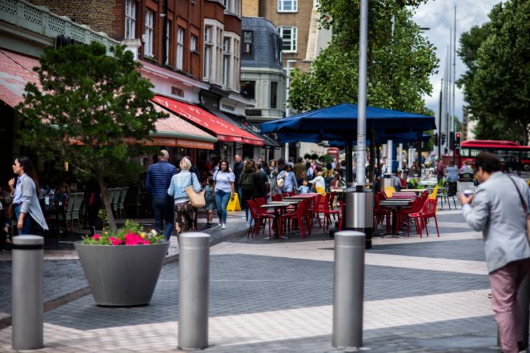 A pedestrianised streets with shops and restaurants and outside seating