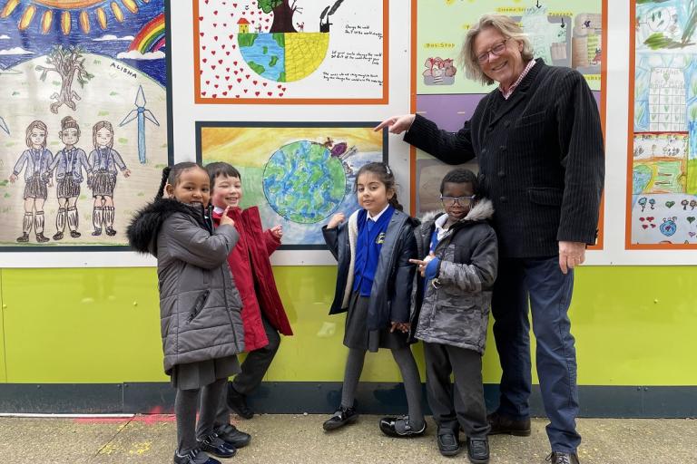 Pupils show off their artwork outside New Homes site