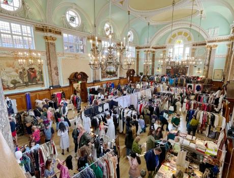 An aerial view of shoppers and clothing stalls at a vintage clothing fair